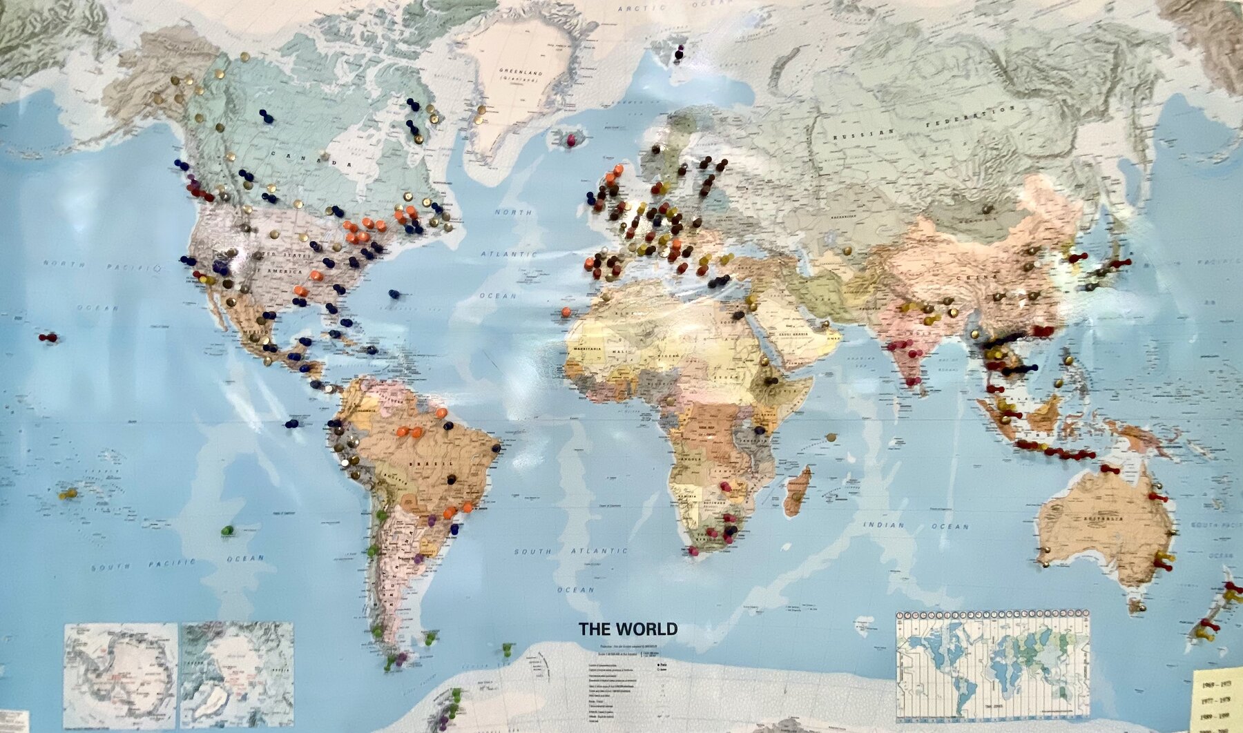 World map studded with colourful pins marking decades of travel